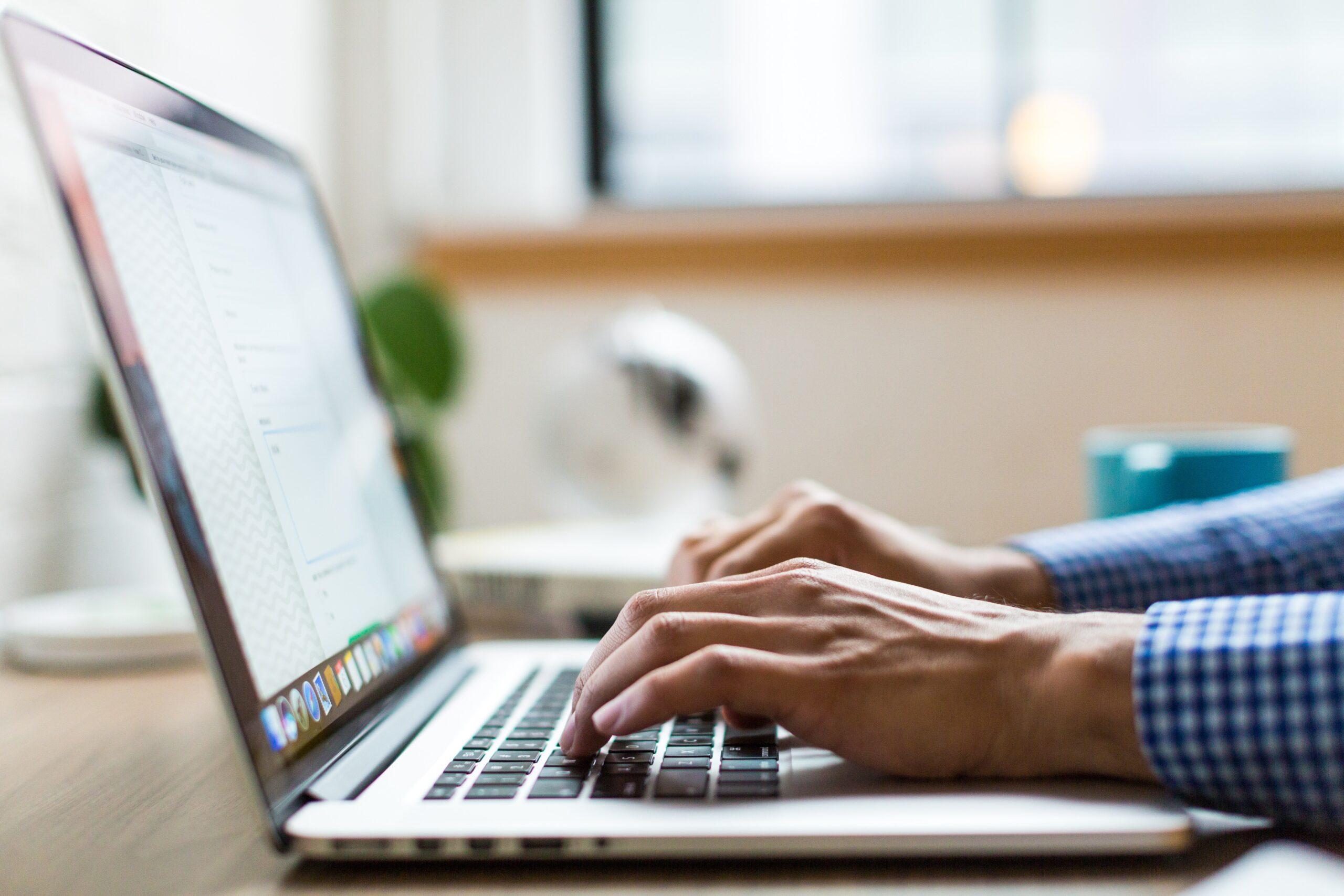 person writing on Macbook laptop