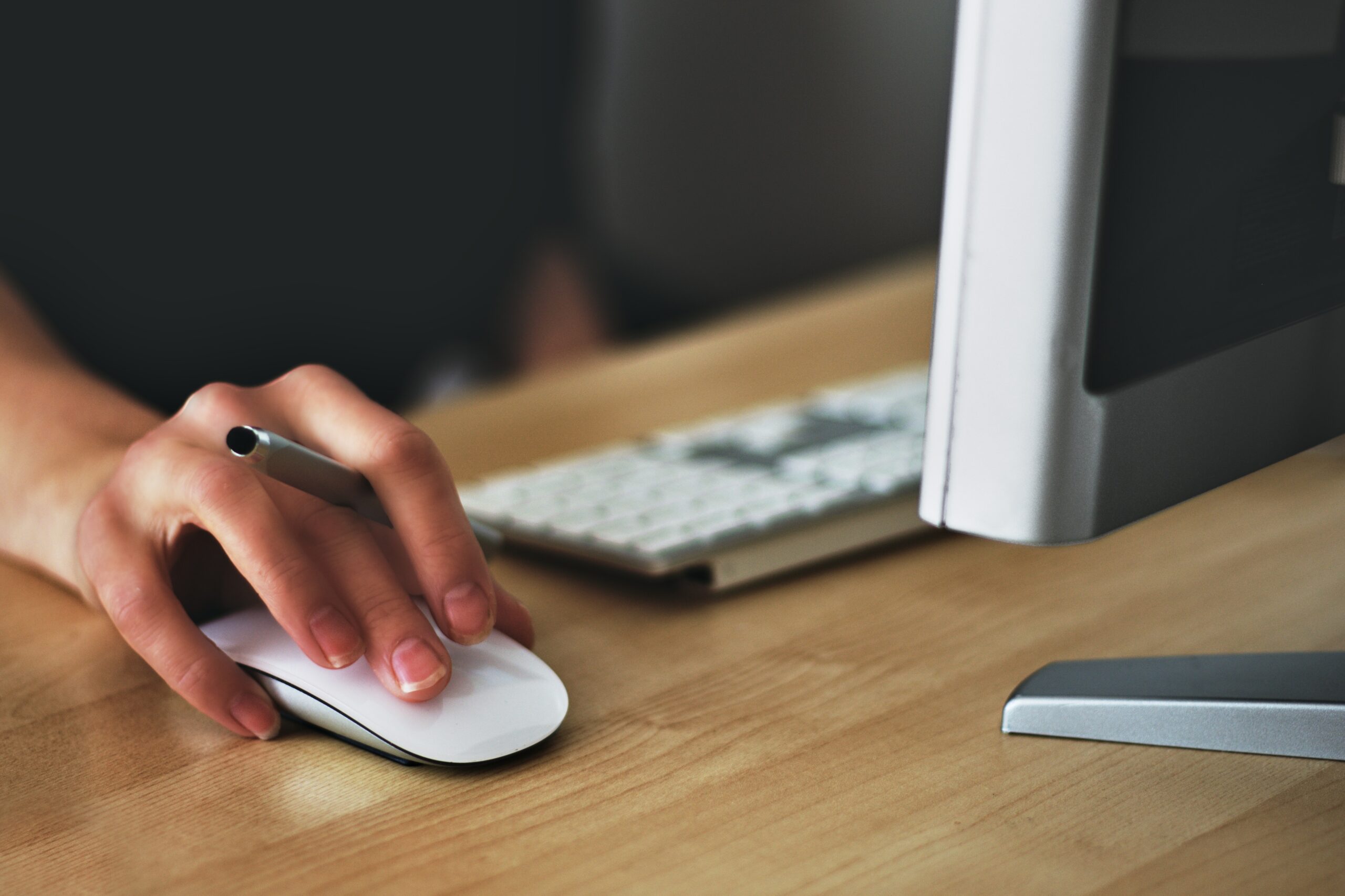 Closeup of a female graphic designer's hand on an Apple computer mouse.