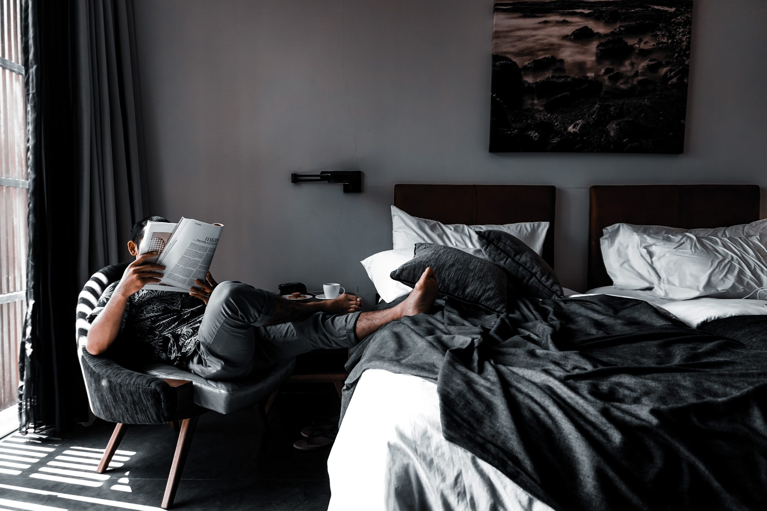 Man reading magazine in bedroom